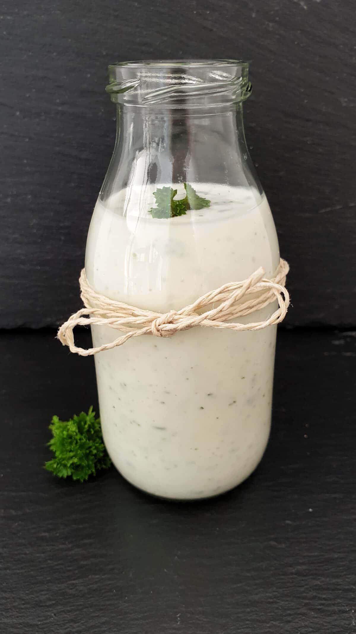 In einer Glasflasche ein selbstgemachtes Joghurt-Dressing.