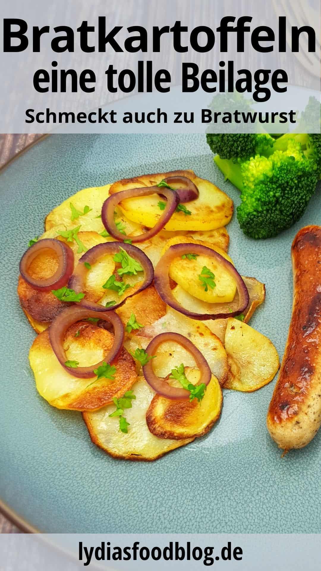 Knusprige Bratkartoffeln mit roten Zwiebel und einer Bratwurst auf einem blauen Teller.