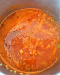 In einem Topf eine rote Curry-Suppe.