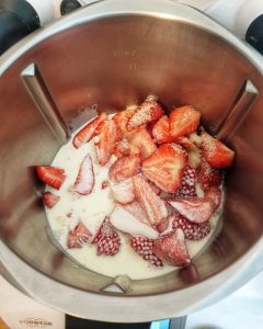 Im Mixtopf des Thermomix Erdbeeren mit Sahne und Zucker.