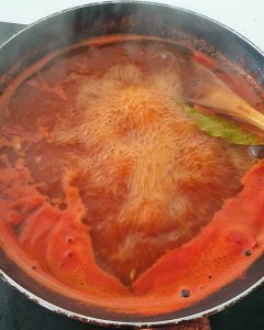 Hier sieht man in einem Topf die tomatige Soße für den Auflauf köcheln.