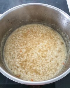Der Reis wird in einem Topf mit Gemüsebrühe und einer Prise Salz gekocht. Auf dem Foto zu sehen ist der Topf mit dem Reis.