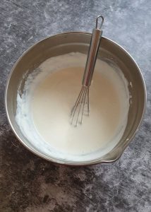 In einer silbernen Schale cremig angerührter Joghurt.