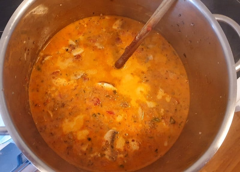 In einem Topf eine Suppe mit Hackfleisch und Pilzen.