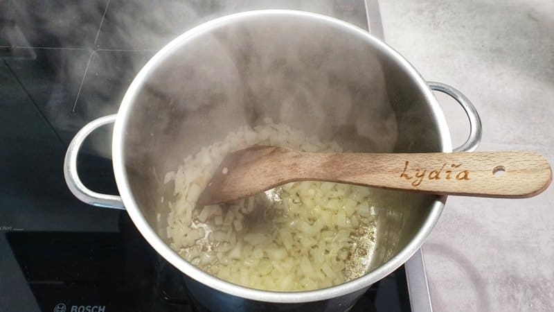 für die Kartoffelsuppe: Die Butter in einem Topf erhitzen und die Zwiebel darin andünsten
