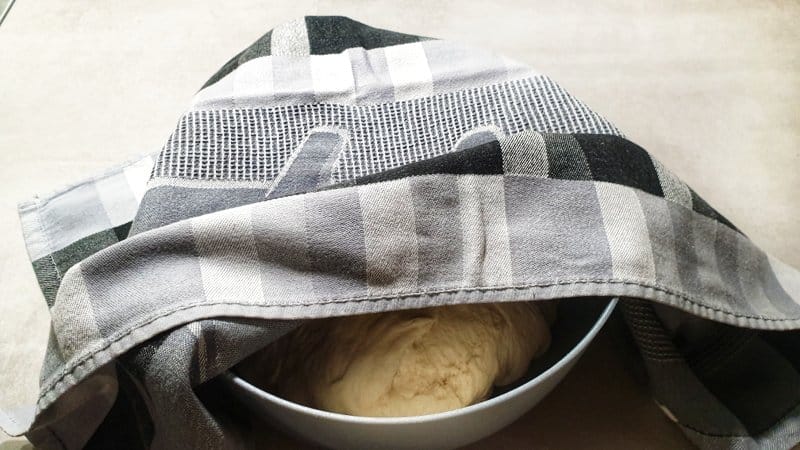 Teig für Brötchensonne / Partybrötchen aus Hefeteig in einer Schüssel mit einem Handtuch zugedecket.