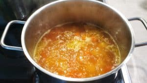 Die Zutaten für die Kokos-Spinat-Suppe werden klein geschnitten und nach kurzem Anbraten der Zwiebel und Möhre mit Gemüsebrühe abgeköscht.
