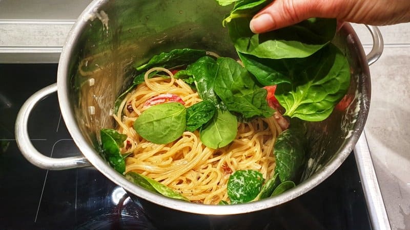 In einem Topf Spaghetti mit Gemüse und frischem Spinat.