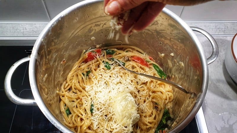 In einem Topf Spaghetti mit Gemüse und frischem Spinat und geriebenem Parmesan.