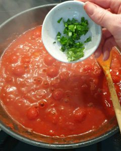In einer Pfanne Tomaten-Soße mit Basilikum.