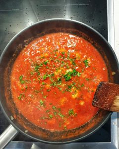 Frische Petersilie in Tomatensoße für die Spaghetti mit Garnelen und Tomatensoße.