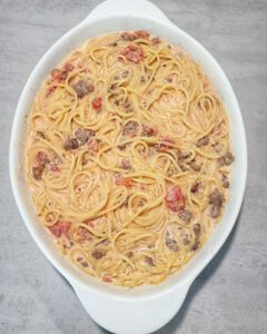 Spaghetti mit Sahne-Soße , Tomaten und Hackfleisch in einer Auflaufform.