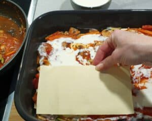 Lasagne Platten auf einer Tomatensoße mit Béchamelsoße.