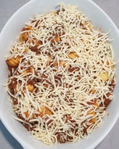 In einer weißen Auflaufform angebratene Gnocchi mit Bolognese Soße und Käse.