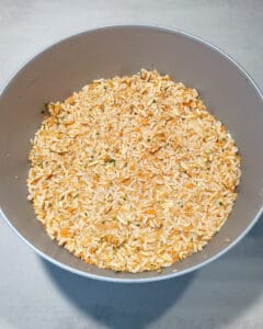 In einer grauen Schale eine vegetarische Masse aus Reis und Möhren für Frikadellen.